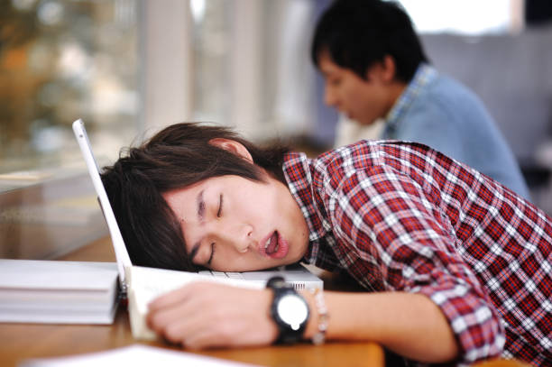 Asian College Student Sleeping College Student sleeping on his laptop when he should be studying. iStockalypse Tokyo 2010. male college student sleeping through lecture stock pictures, royalty-free photos & images