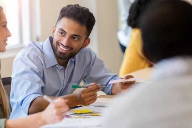 istock Cheerful male creative professional talking with colleague 1098428510