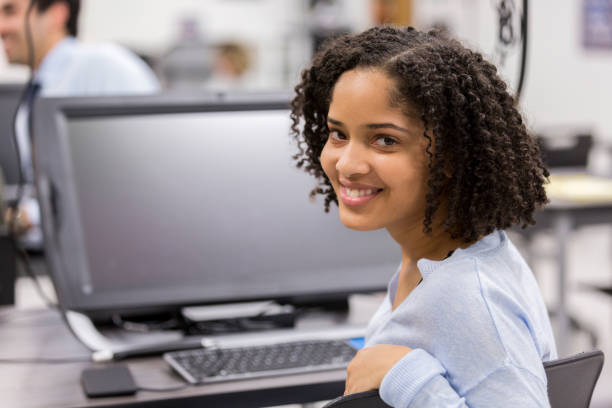 istock Cheerful high school girl in computer lab 1098429300
