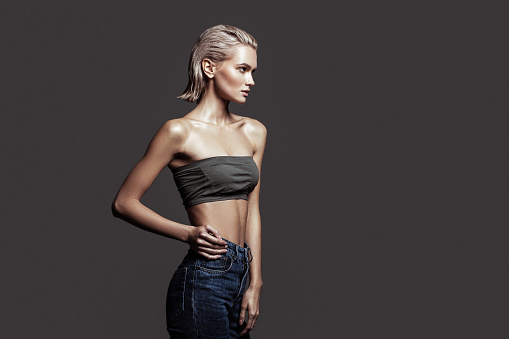 Model with bob. Slim blonde-haired model with bob cut wearing nice jeans and open shoulder top