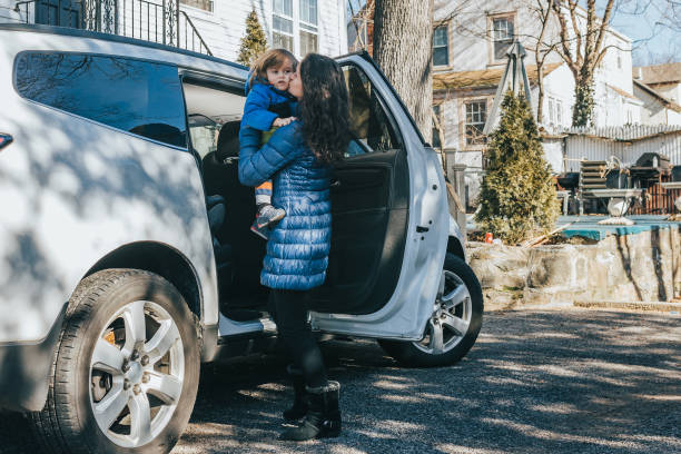 istock Woman putting child in car seat 1098433202
