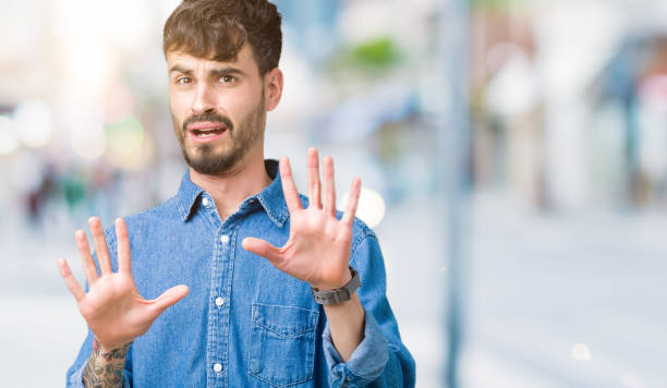 istock Young handsome man over isolated background afraid and terrified with fear expression stop gesture with hands, shouting in shock. Panic concept. 1098435934