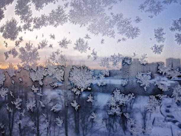 Christmas frosty snowflake pattern on the window glass at sunrise, St. Petersburg, Russia stock photo