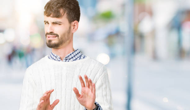 istock Young handsome man wearing winter sweater over isolated background disgusted expression, displeased and fearful doing disgust face because aversion reaction. With hands raised. Annoying concept. 1098437792