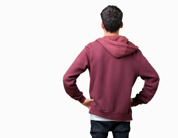 Young handsome man over isolated background standing backwards looking away with arms on body Young handsome man over isolated background standing backwards looking away with arms on body body adornment rear view young men men stock pictures, royalty-free photos & images