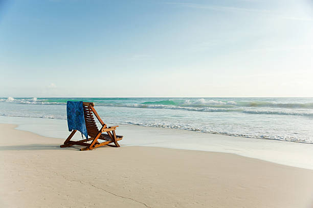 silla reclinable en la playa de arena en water's edge - outdoor chair beach chair sarong fotografías e imágenes de stock