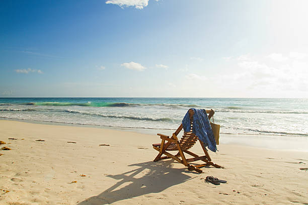 silla reclinable en la playa de arena en water's edge - outdoor chair beach chair sarong fotografías e imágenes de stock