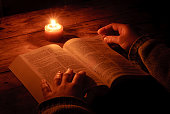 Relaxing and reading bible by candlelight at night