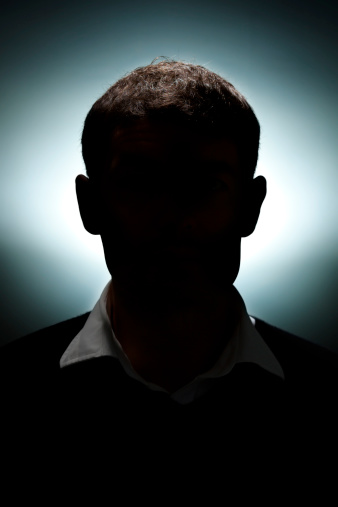 A portrait of a man lit with only a hair light and a background light.