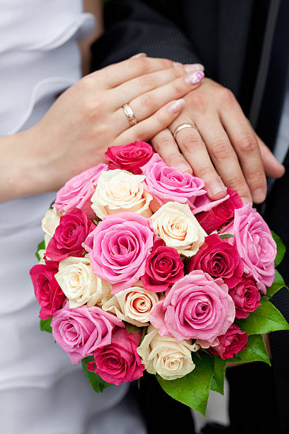 istock hands of the bride and groom lying on  bouquet 110858726