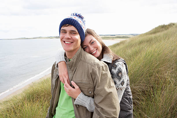 istock Young Couple Walking Through Sand Dunes Wearing Warm Clothing 110862811
