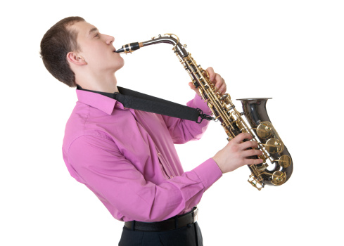 Boy holding his saxophone outdoors