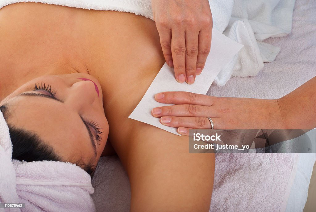 Woman getting her armpit waxed at a salon Beautician waxing armpit to a woman in a salon Beauty Spa Stock Photo