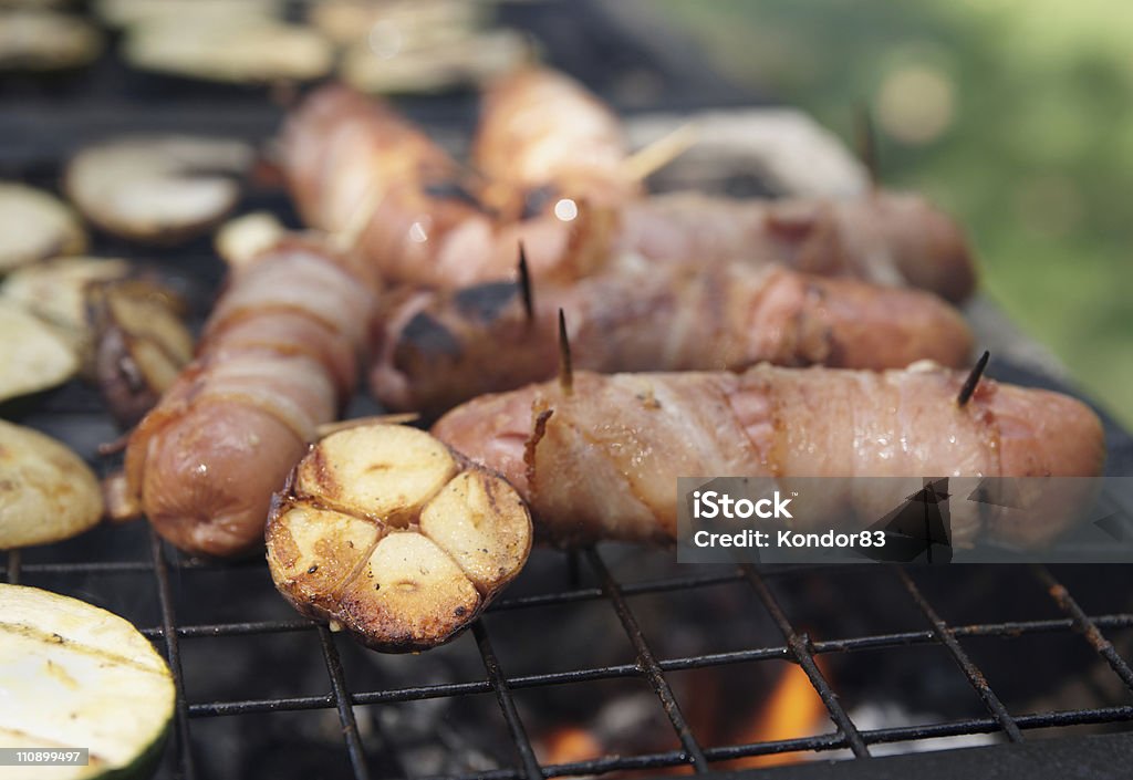 Saucisses enveloppé dans du bacon et de légumes au grill - Photo de Ail - Légume à bulbe libre de droits
