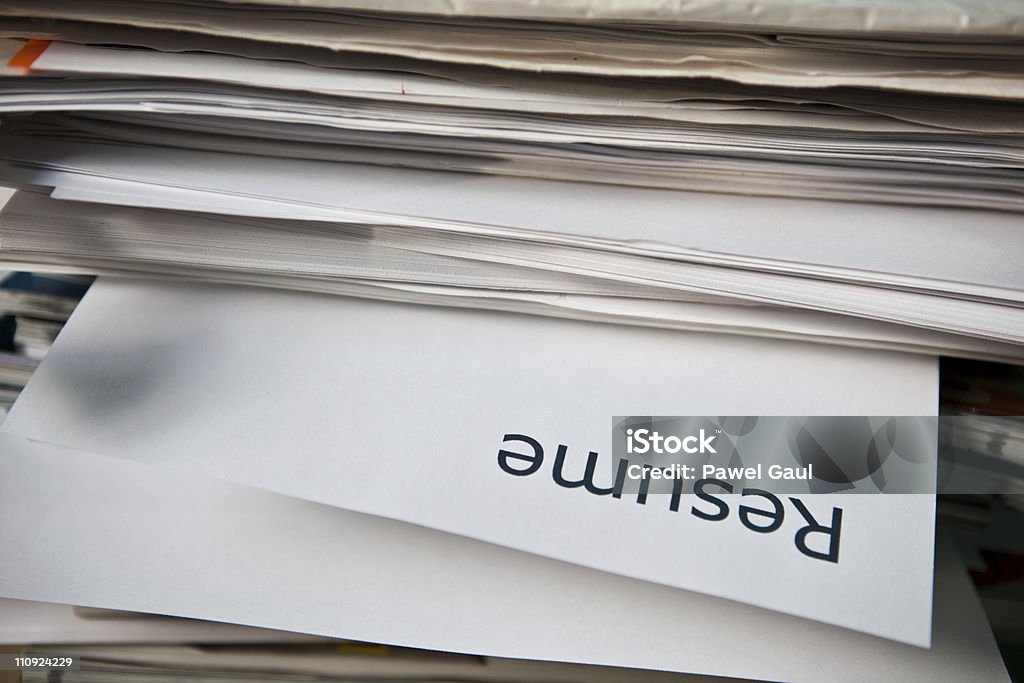 Resume Resume sticks out of a pile of documents. Paper Stock Photo