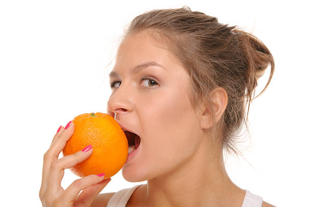 istock Young woman bites an orange 110934890