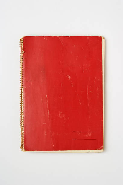 Isolated shot of old red spiral notebook on white background