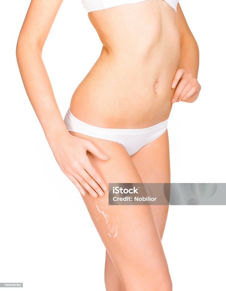 Slim girl distribuye crema en sus piernas - Foto de stock de Adulto libre de derechos