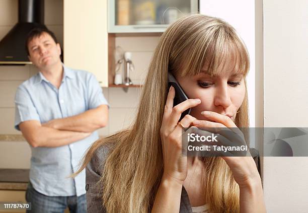 Wife Talking On Phone While Husband Watches Stock Photo - Download Image Now - Infidelity, Mobile Phone, Eavesdropping