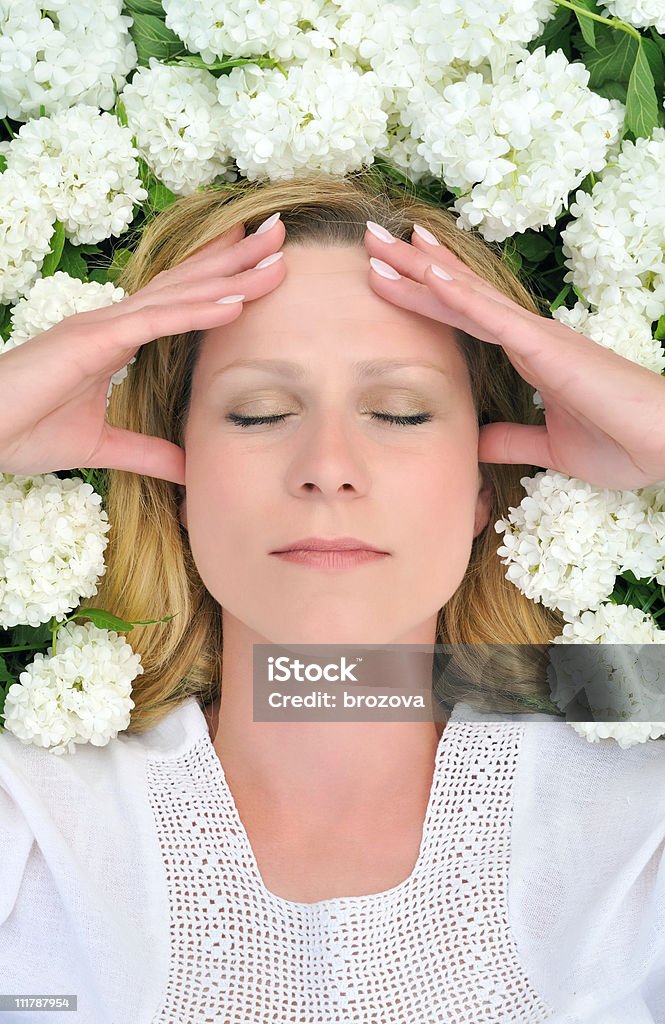 Jeune femme soulevant dans des fleurs-boules de neige - Photo de Adulte libre de droits