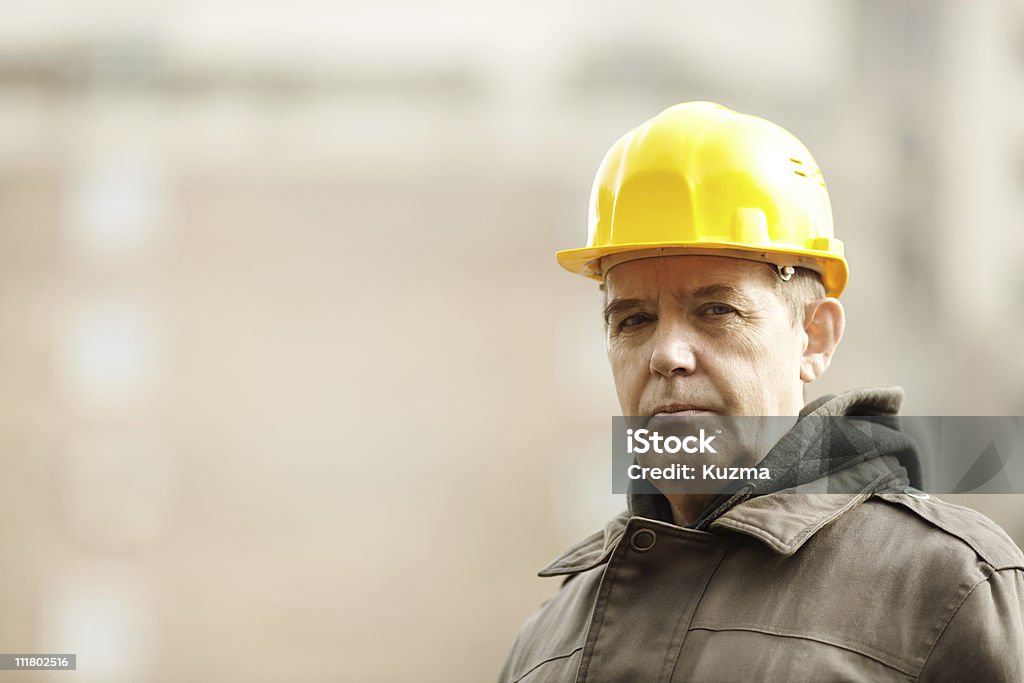 Wise construction real experienced builder with yellow hardhat, natural light Candid Stock Photo