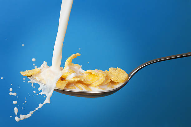 istock milk splashing into spoon with cornflakes 111821975
