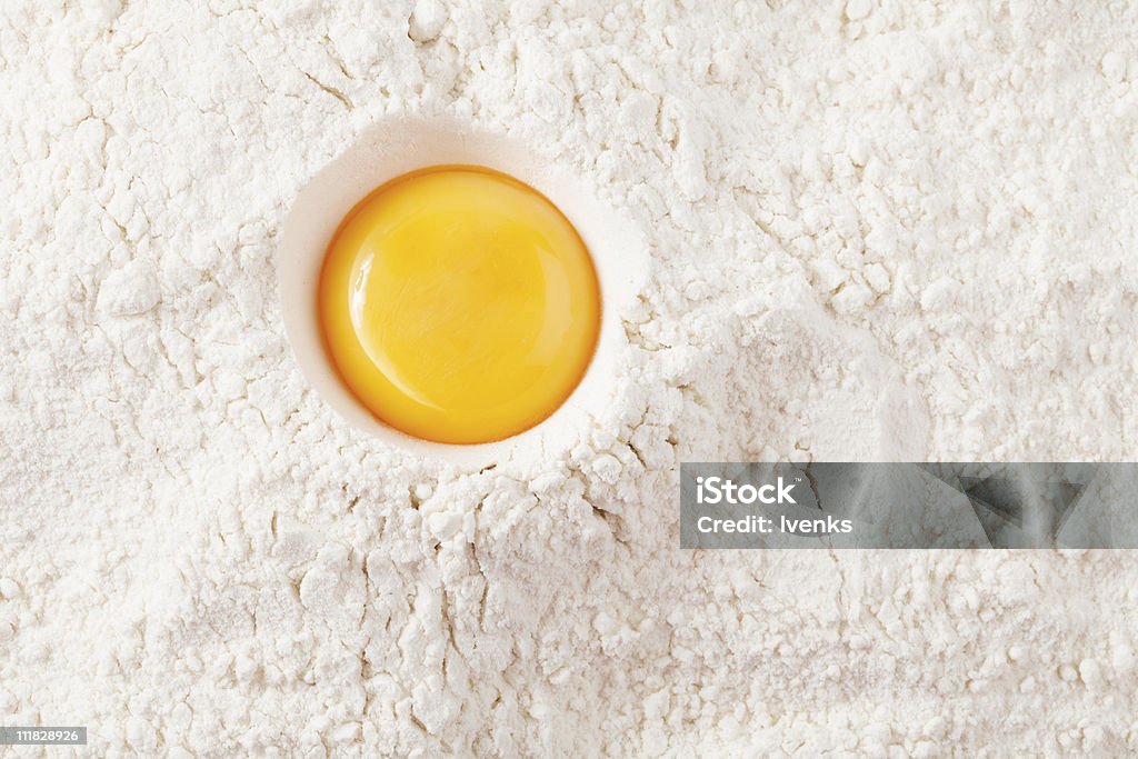 love to bake it!  egg  yolk on flour, full frame  Animal Egg Stock Photo