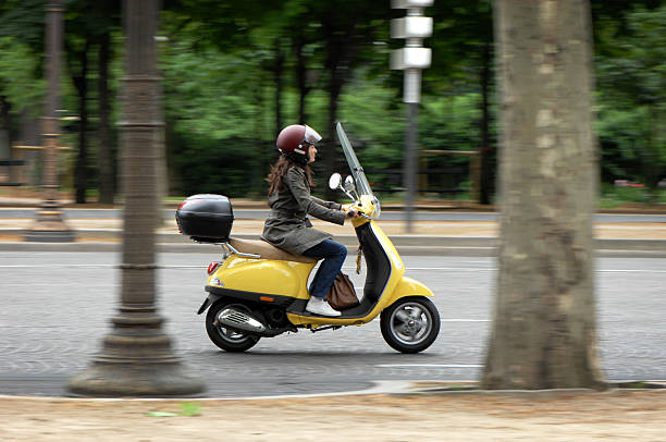hembra scooter rider in paris france - ciclomotor fotografías e imágenes de stock