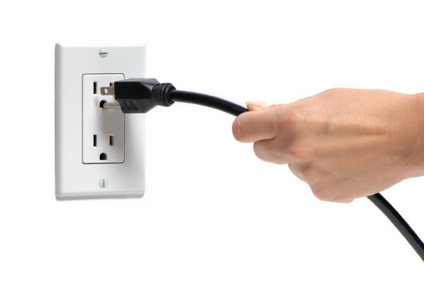Woman's Hang Pulling Plug Out of Socket on White Woman's Hang Pulling Plug Out of Socket on White wired stock pictures, royalty-free photos & images