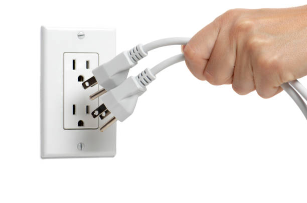 女性のプルプラグのコンセントから白背景 - electric plug outlet pulling electricity ストックフォトと画像