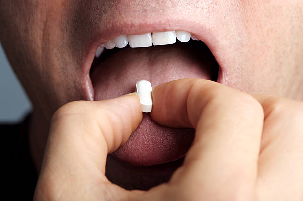 istock Man Taking Pill Extreme Close up 111870226