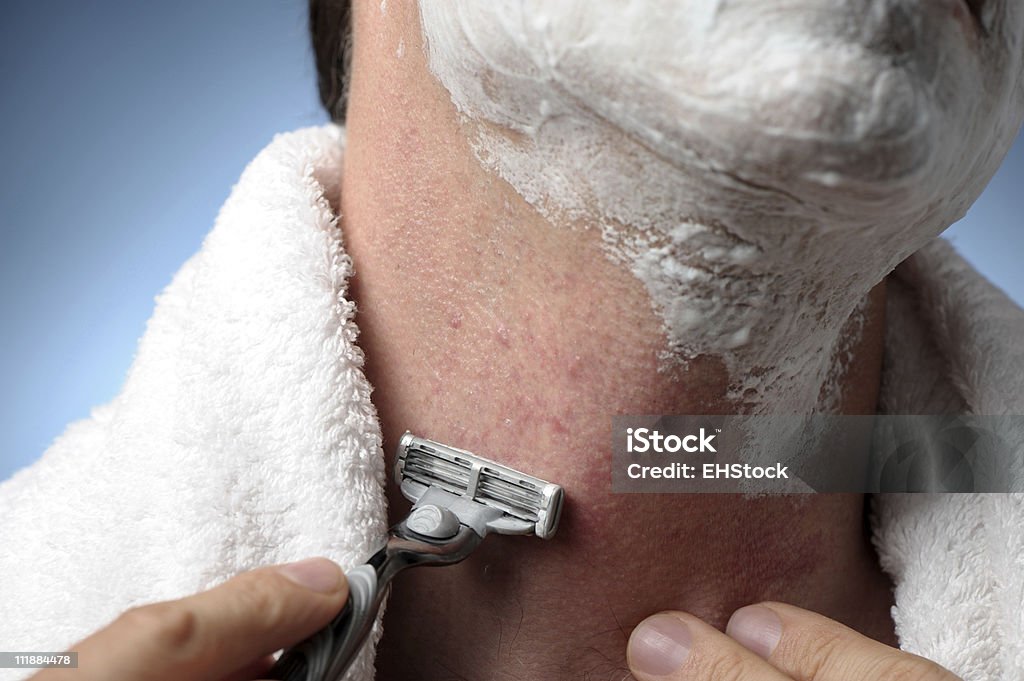 Man Shaving with Razor Burn Close up of man shaving with razor and towel and razor burn and bumps Shaving Stock Photo