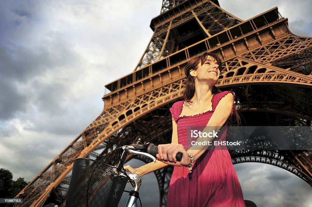 Jovem mulher com bicicleta abaixo da torre Eiffel, Paris, França - Foto de stock de Bicicleta royalty-free