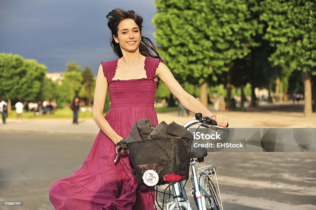 Молодая женщина, ходьба с велосипеды в парке - Стоковые фото Весёлый роялти-фри