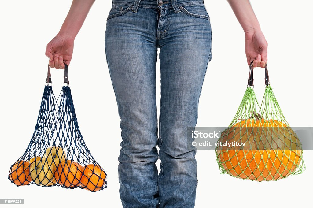 Woman with string shopping bags (Einkaufsnetz) carrying different yellow fruits  Carrying Stock Photo
