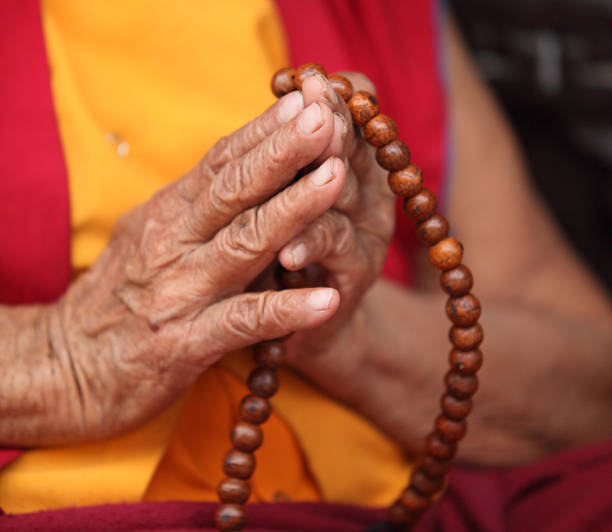 Buddhist Nun praying with Mala Prayer beads stock photo