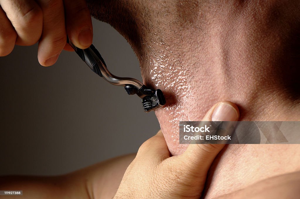 Mann Rasieren mit Rasierbrand Holding Hals dunklen grauen Hintergrund - Lizenzfrei Rasierer Stock-Foto