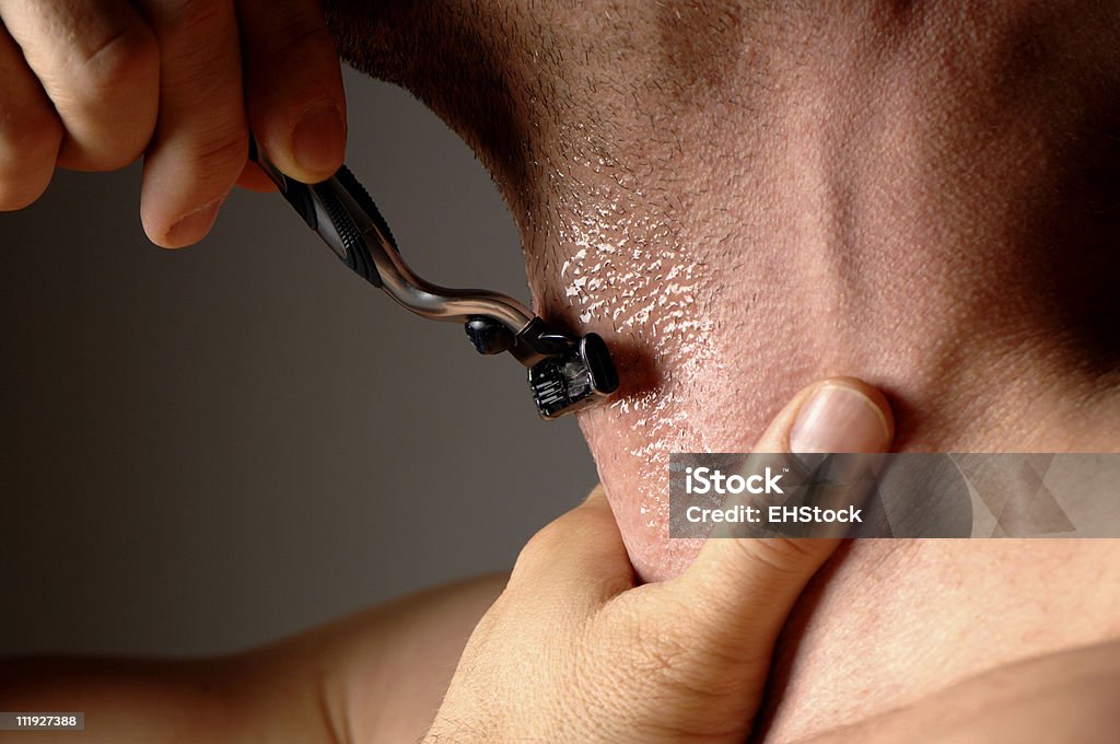 Man Shaving with Razor Holding Throat Dark Gray Background Razor Stock Photo