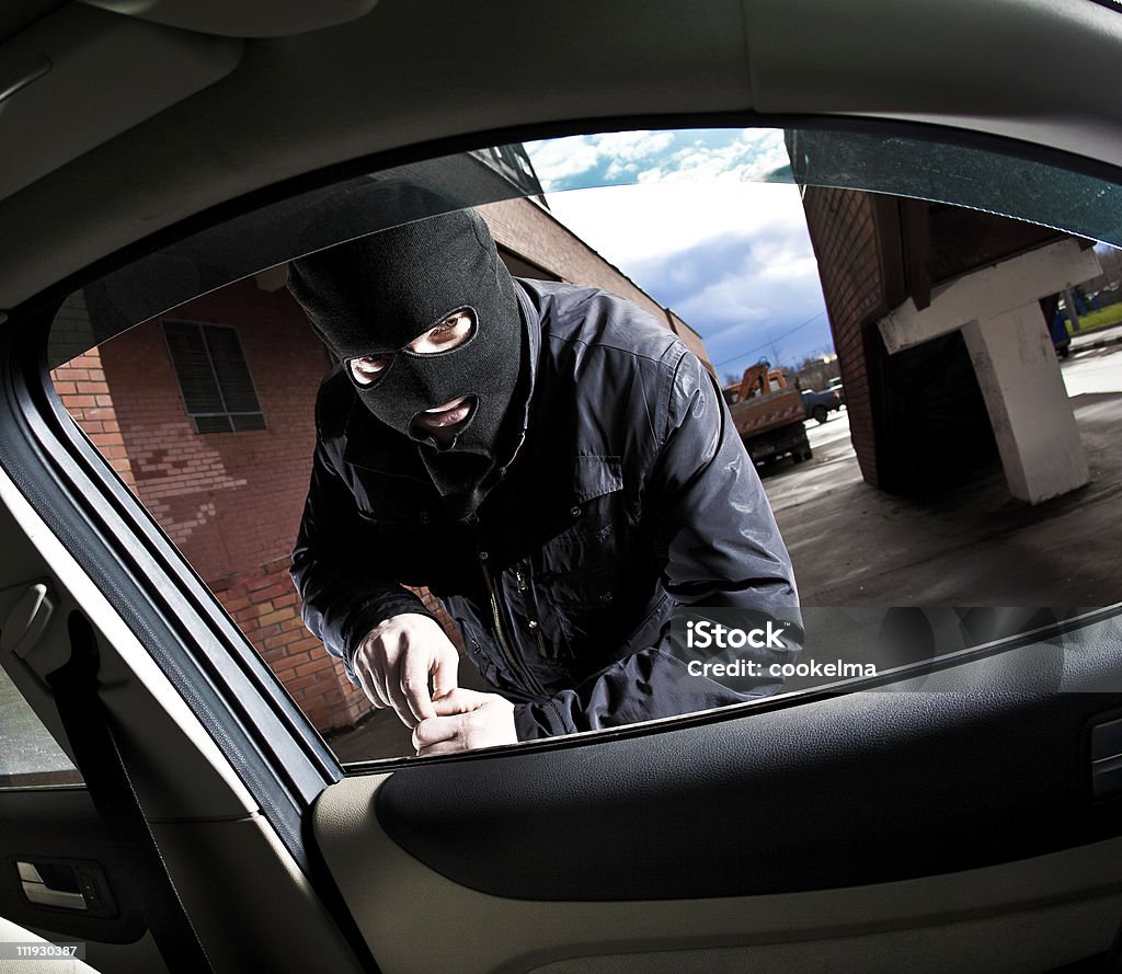 A car burglar attempting to break in robber and the thief hijacks the car Adult Stock Photo