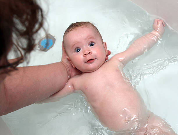 istock baby girl bath by mother 111930614