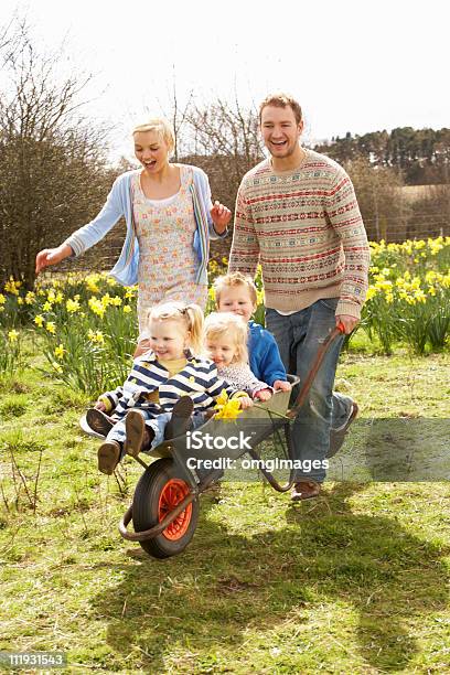Father Giving Children Ride In Wheelbarrow Stock Photo - Download Image Now - Springtime, Family, Formal Garden