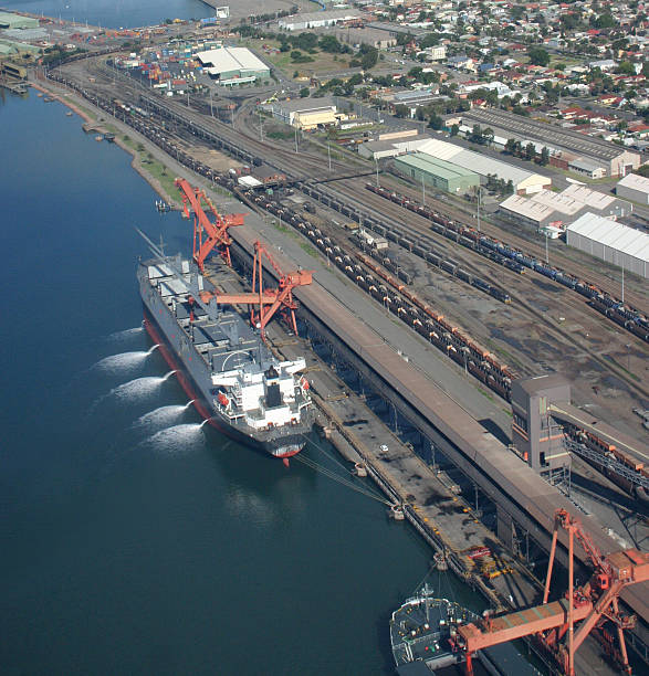 Boat in the water loading coal Aerial view of a coal ship pumping out its ballast tanks whilst it is loaded with coal. Newcastle Australia, southern hemisperes largest coal exporting port. newcastle new south wales stock pictures, royalty-free photos & images