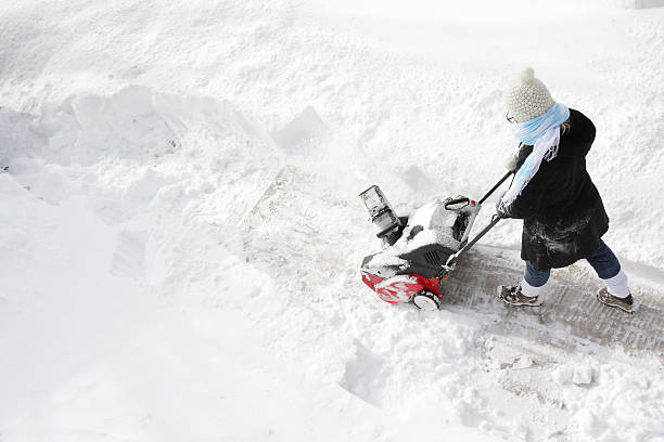 Mid adult man using snowblower after heavy snowfall at backyard