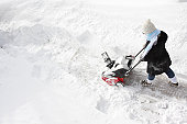 Woman removing snow with a snowblower