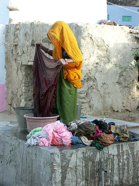 Indian lady  washing clothes at a waterpump ina village in  Rajasthan,India.