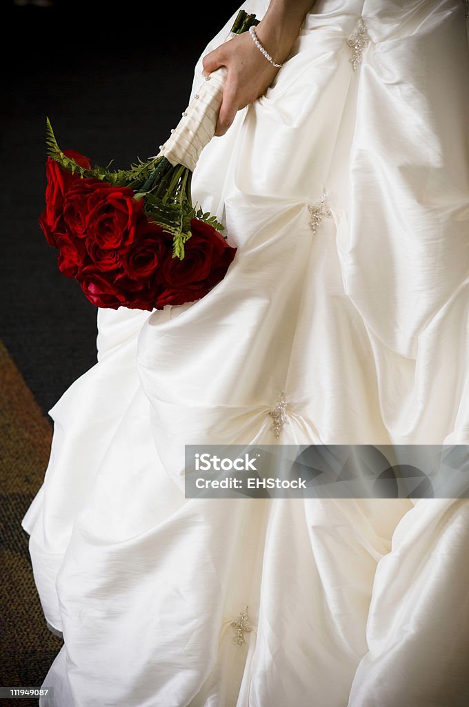 Red Bouquet and Bridal Gown Bridal bouquet of red roses held against wedding gown	http://www.erichoodphoto.com/istock/weddingbanner.jpg Adult Stock Photo