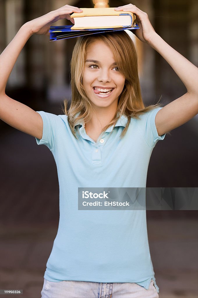Aluna adolescente prende a língua enquanto o equilíbrio livros na Cabeça - Royalty-free Adolescente Foto de stock