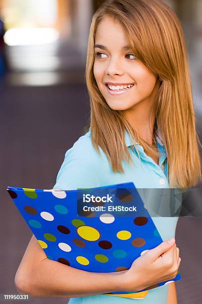 Teenage Schoolgirl Holding Books Looks Over Shoulder Stock Photo - Download Image Now