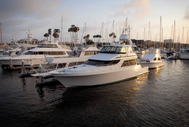 Yachts and Motorboats in Marina del Rey California at Sunset A tidy little yacht sits moored to a dock in Marina Del Rey, California marina california stock pictures, royalty-free photos & images
