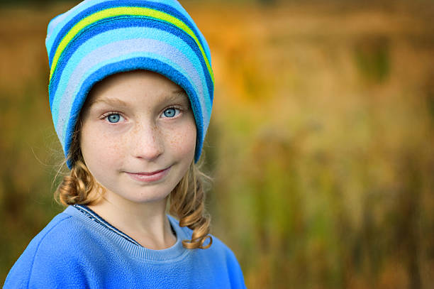 Cute toddler girl outdoors portrait in summer day. Smiling and charming child. Little lady with blonde and curly hair